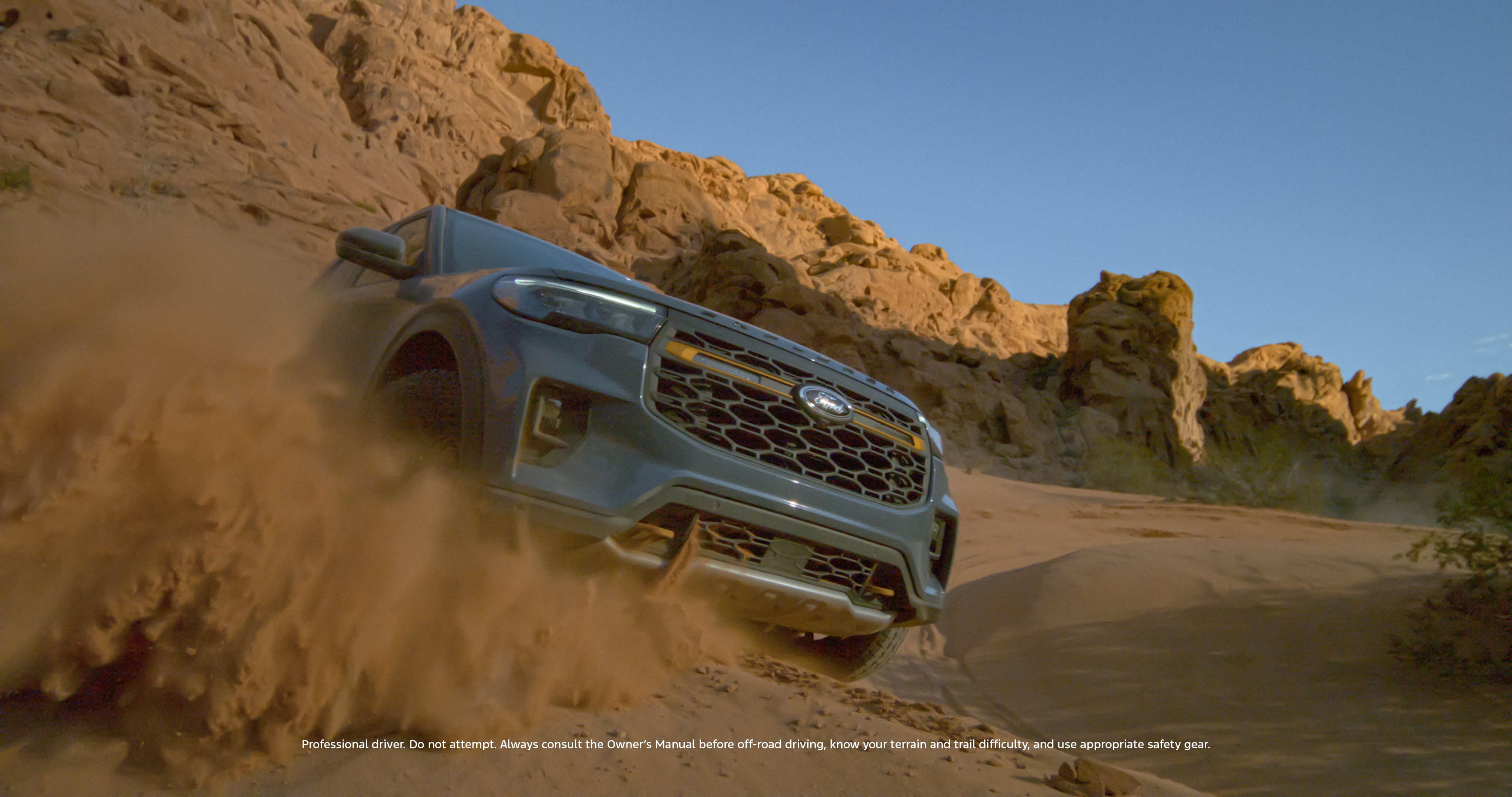 A Ford Explorer kicks up dirt on an off-road trail.
